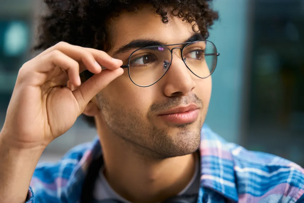Hombre joven probándose unos lentes durante una revisión de la vista