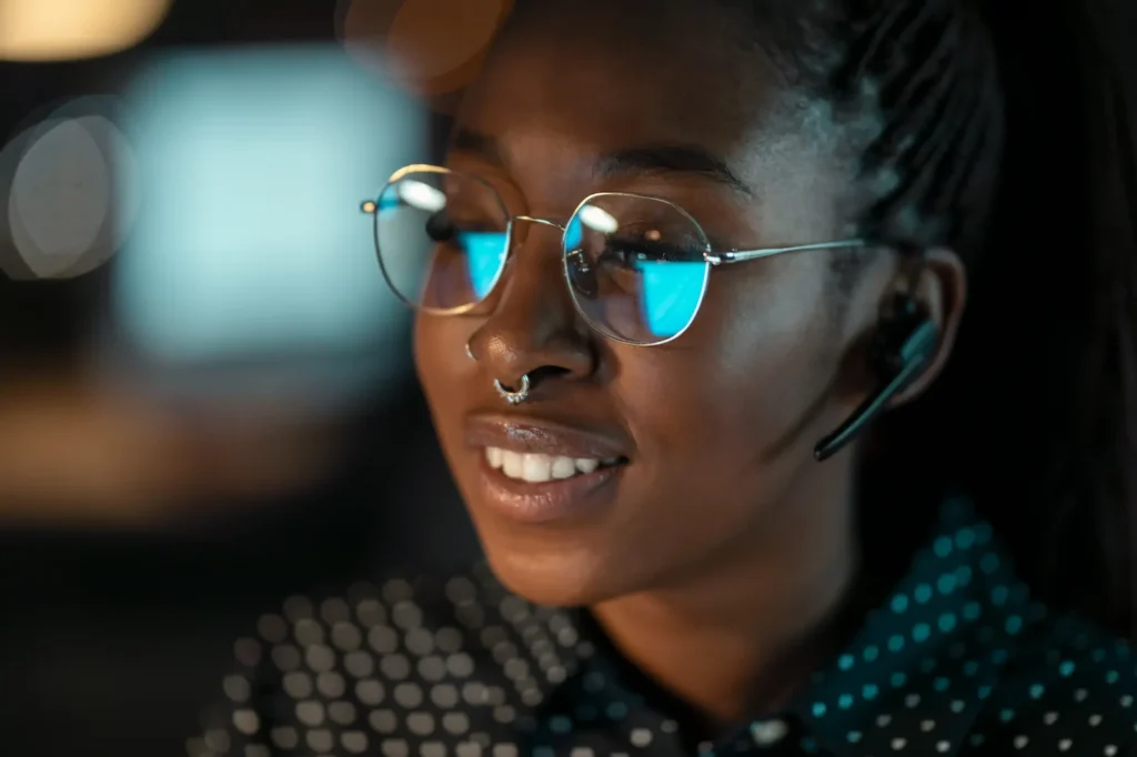 Mujer sonriendo mientras usa lentes con filtro azul.