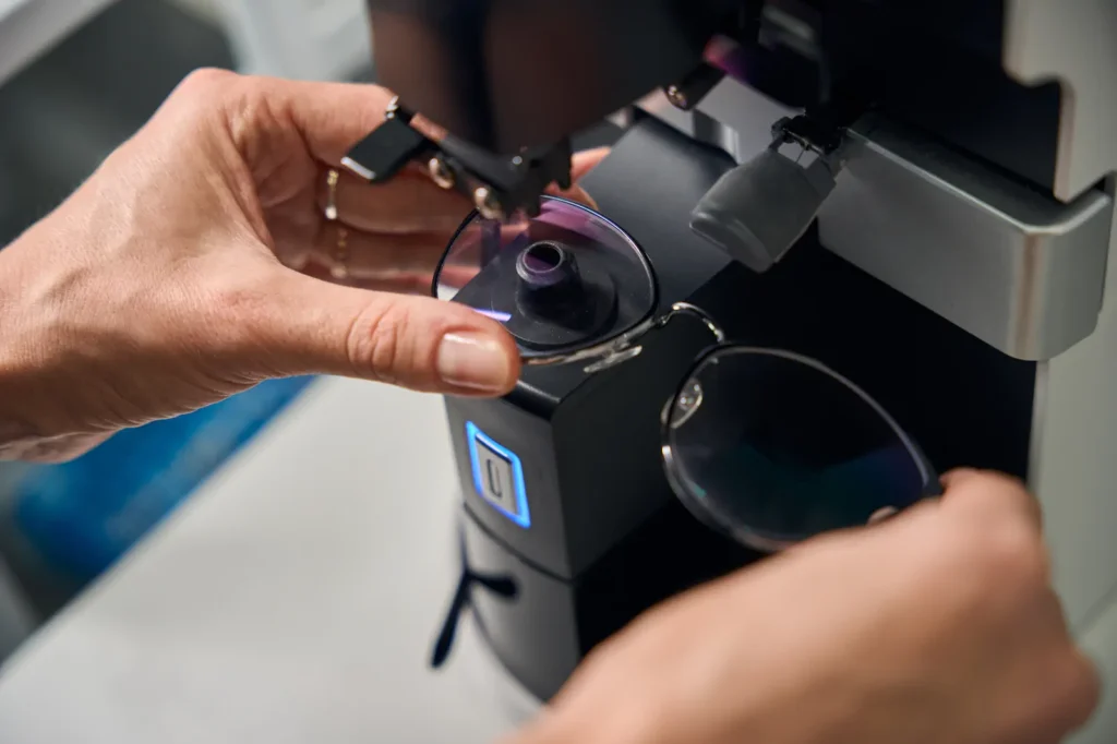 Proceso de fabricación de lentes con filtro azul en máquina óptica.