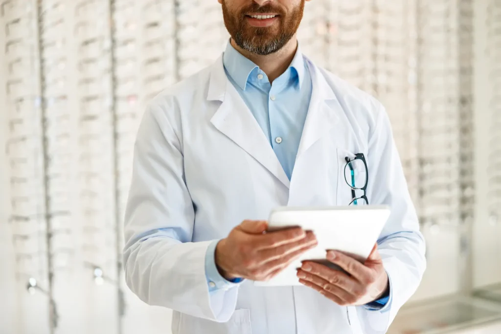 Optometrista con bata blanca sosteniendo portapapeles en clínica de optometría