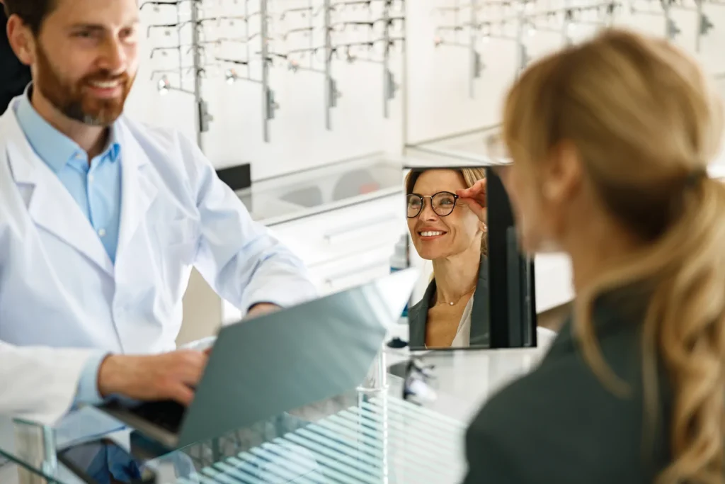 Cliente probándose lentes en óptica con asesoramiento profesional