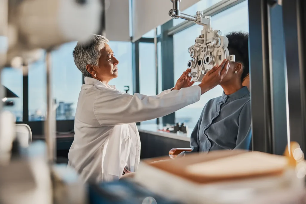Doctora ajustando equipo de refracción durante prueba ocular