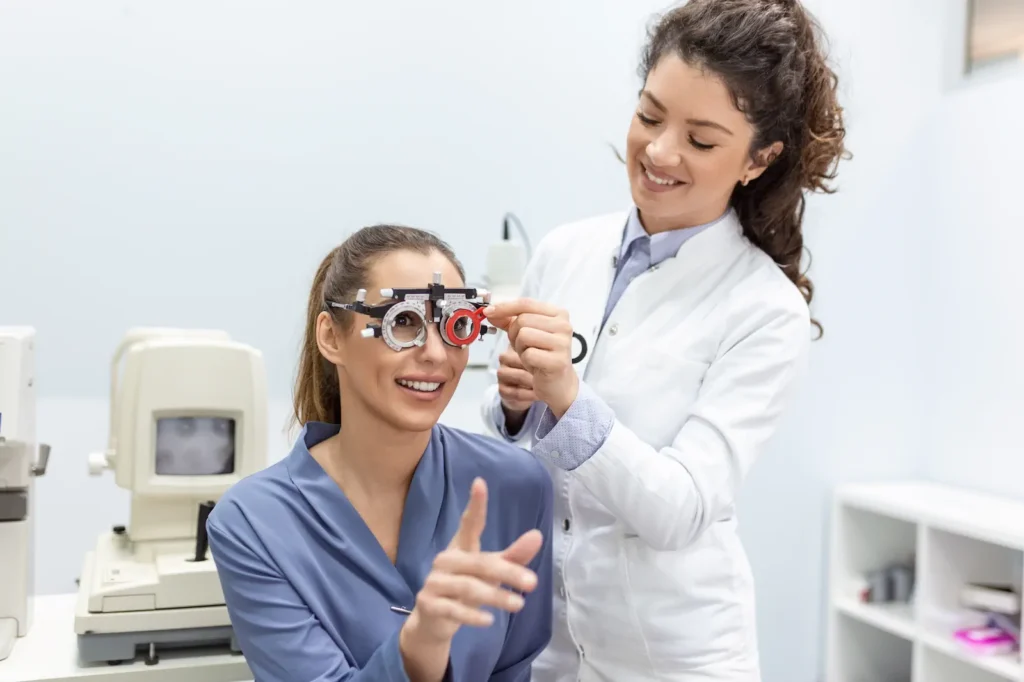 Optometrista colocando lentes de prueba a una paciente sonriente