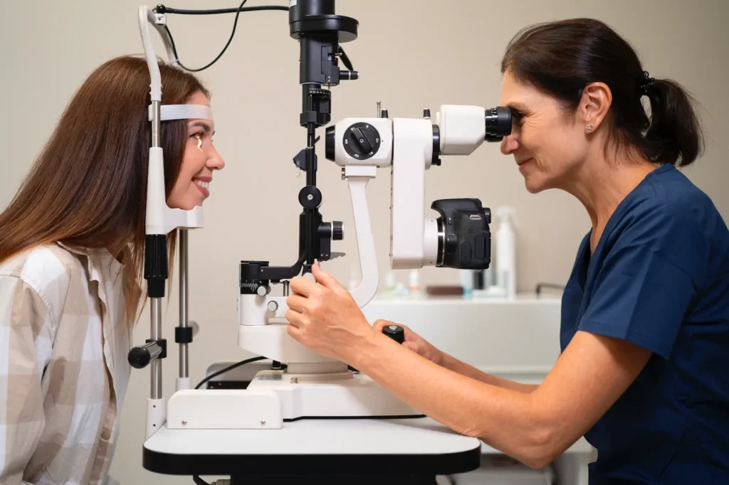 Mujer joven realizándose examen ocular con lámpara de hendidura.