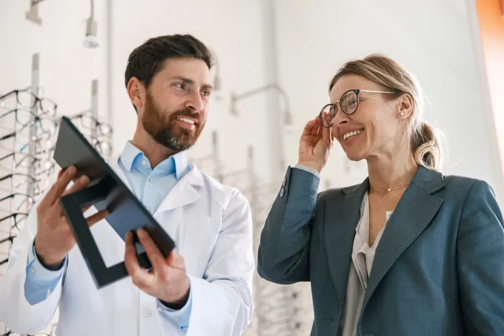 Optometrista mostrando resultados a una paciente durante una revisión visual.