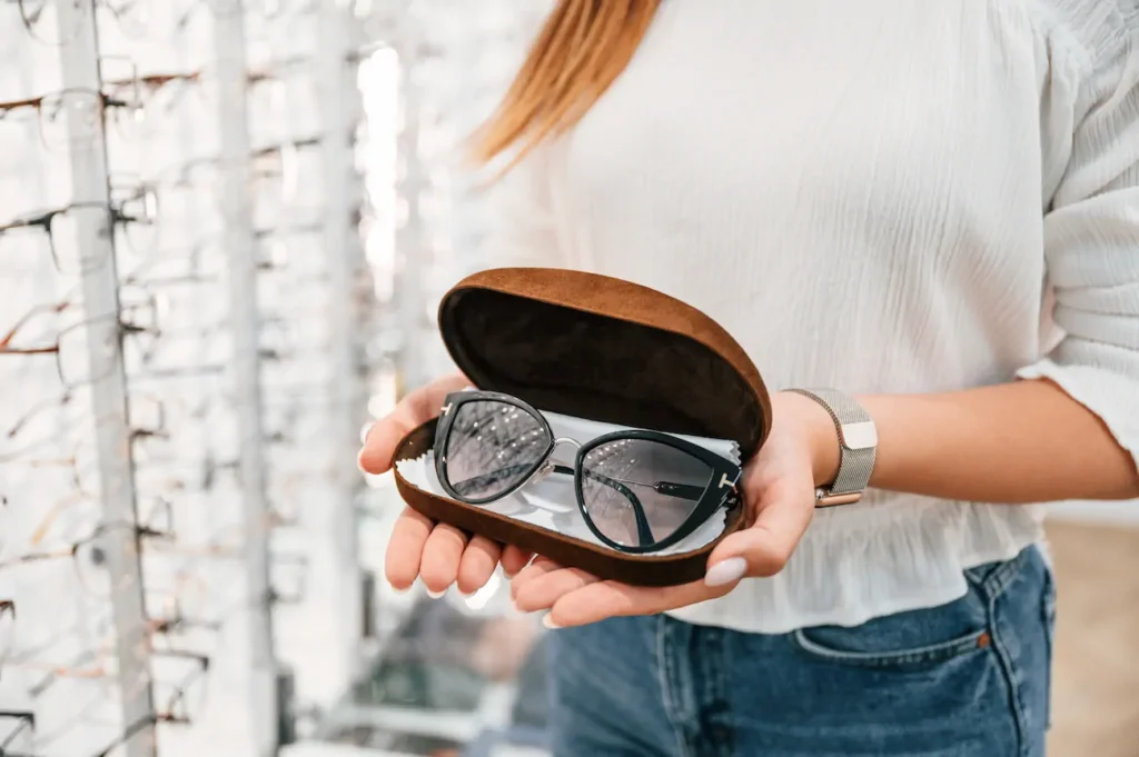 Persona sosteniendo un estuche abierto con lentes dentro.