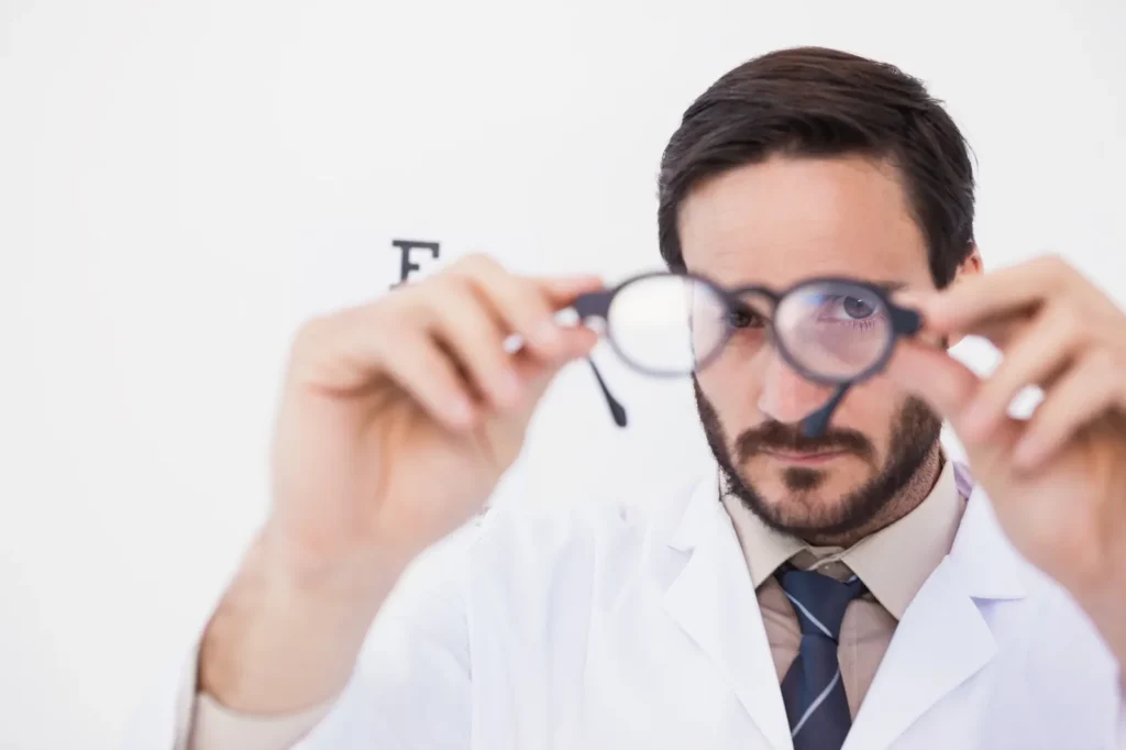Optometrista evaluando unos lentes para corregir astigmatismo durante una revisión profesional.
