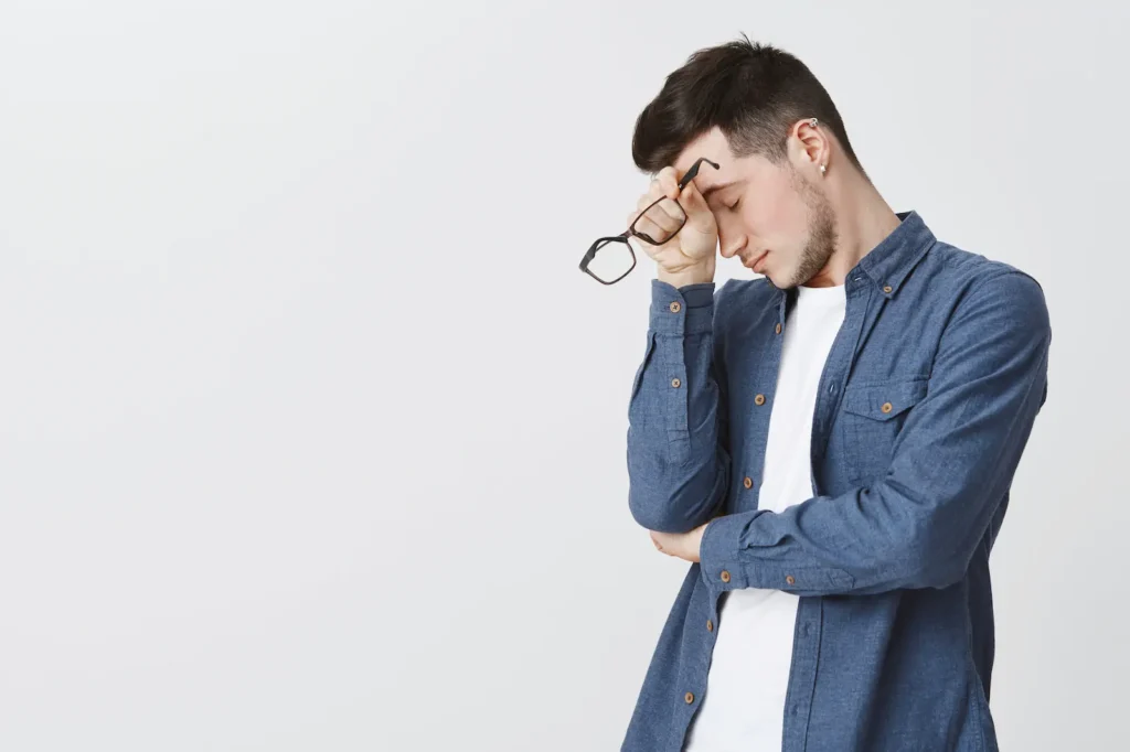 Hombre presionando el puente de la nariz por tensión ocular y dolor de cabeza digital.