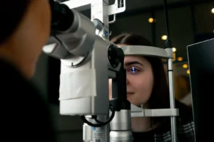 Optometrista realizando diagnóstico visual con foróptero durante jornada corporativa