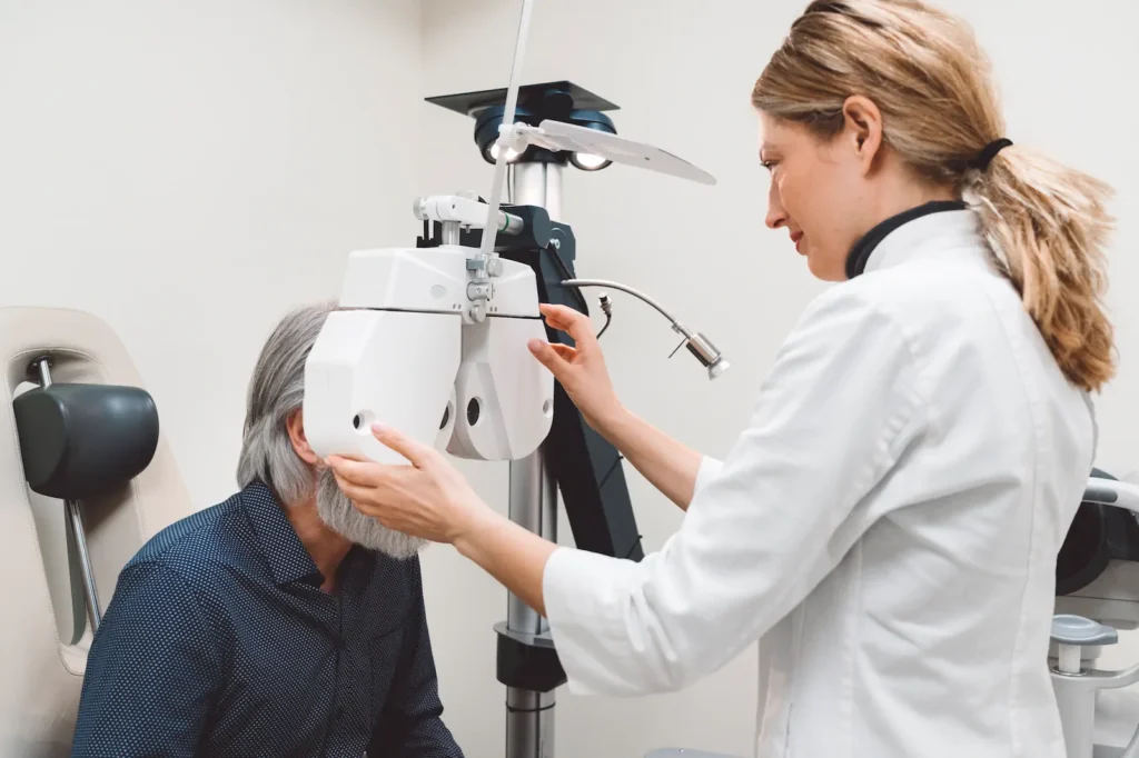 Especialista ajustando equipo de diagnóstico visual en revisión ocular para trabajadores