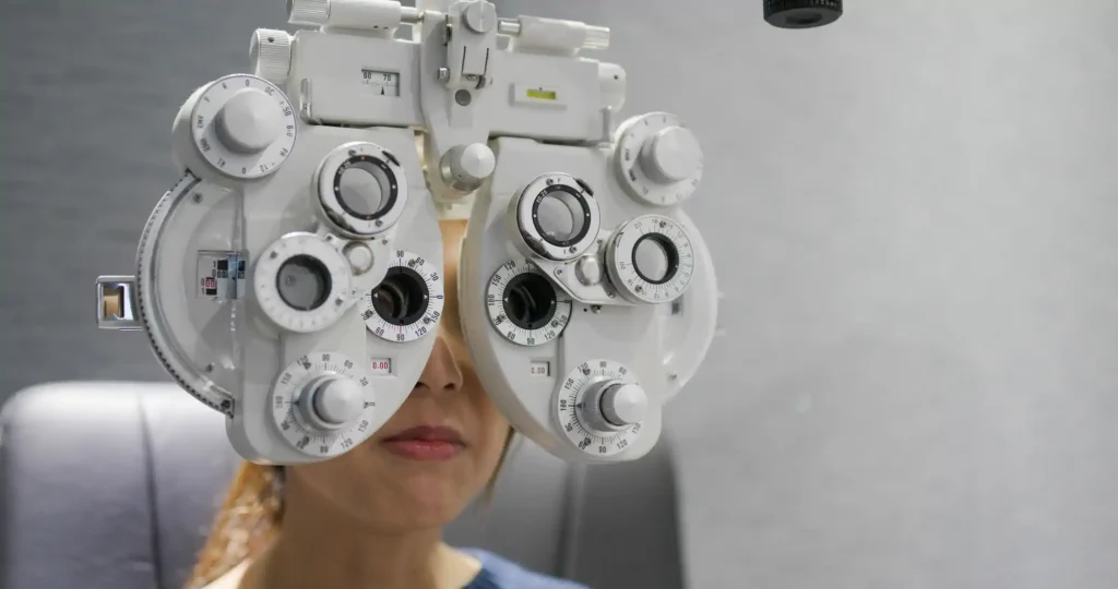 Empleado sometiéndose a prueba de visión con foróptero durante jornada de salud visual empresarial