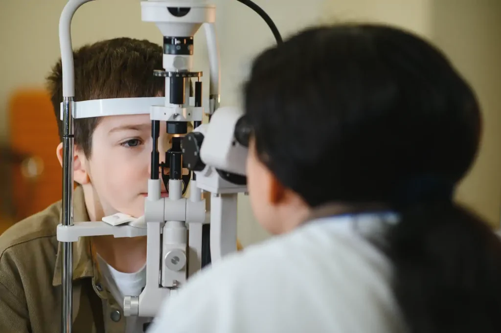 Niño realizándose examen de la vista con lámpara de hendidura en consultorio optométrico