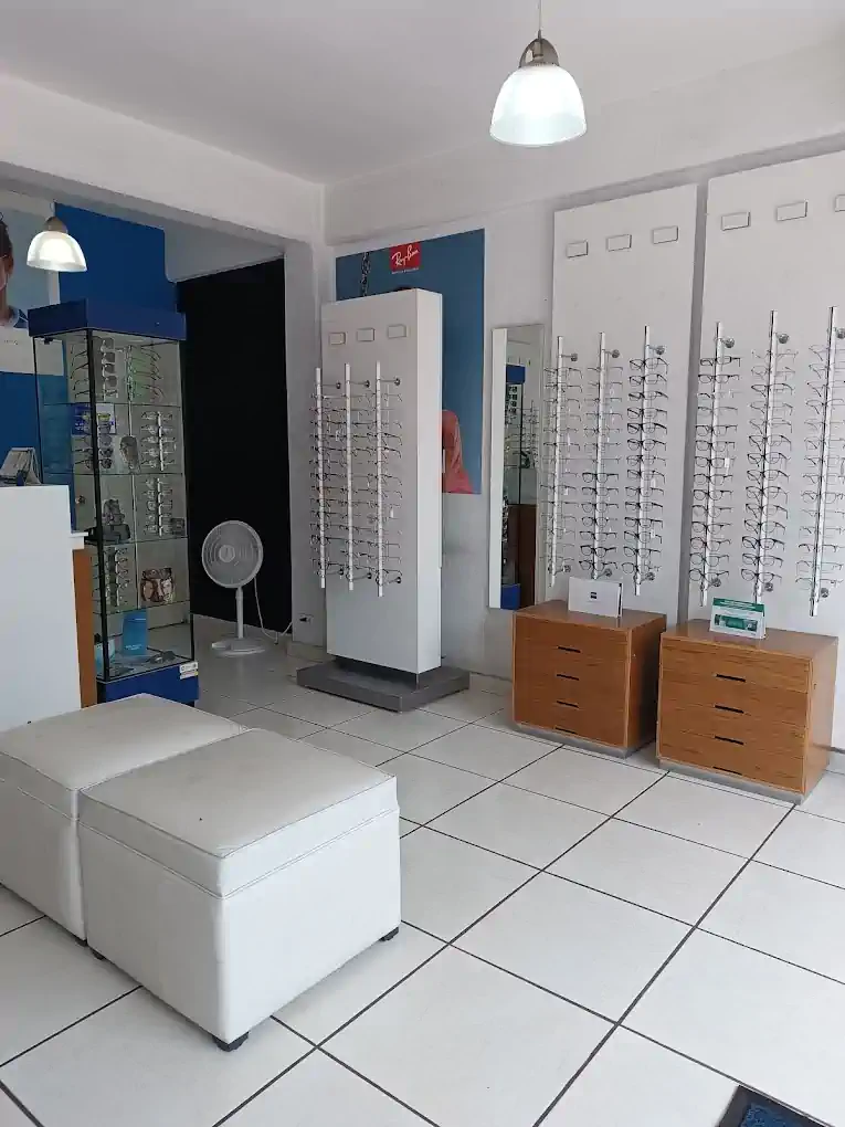 Interior de Ópticas Carey Tláhuac con exhibidores de armazones y área de atención